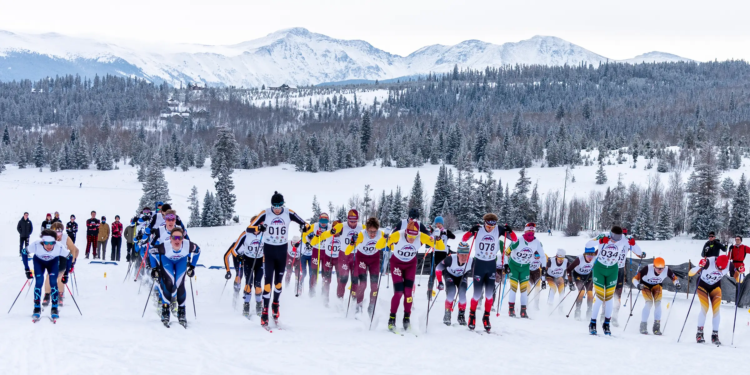 Cross country ski racers starting a race on a snowy mountain course