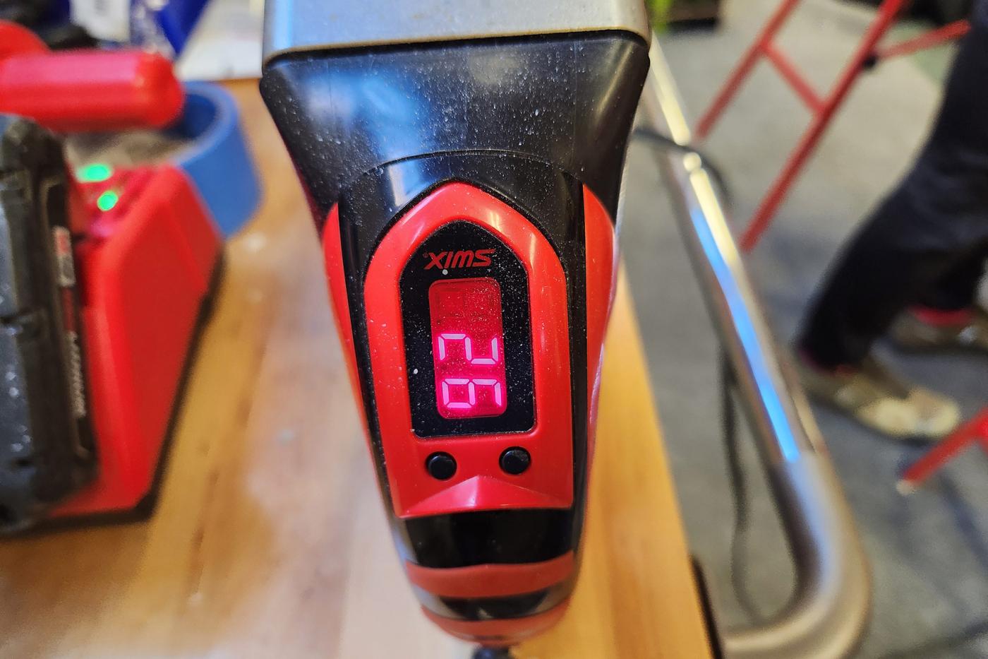 Close-up of a Swix digital waxing iron showing a red LED display set to 124 degrees.