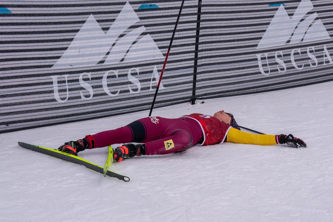 Greta Bochenek of Colorado Mesa University lying on the snow after finishing the 15 km freestyle race at USCSA National Championships, exhausted after her gold medal performance in Lake Placid.
