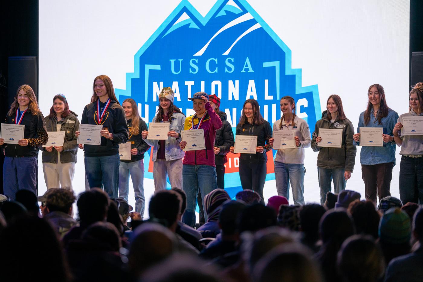 Greta Bochenek of Colorado Mesa University stands on stage after winning first place, recognized among All-American athletes at the USCSA National Championships awards ceremony in Lake Placid.